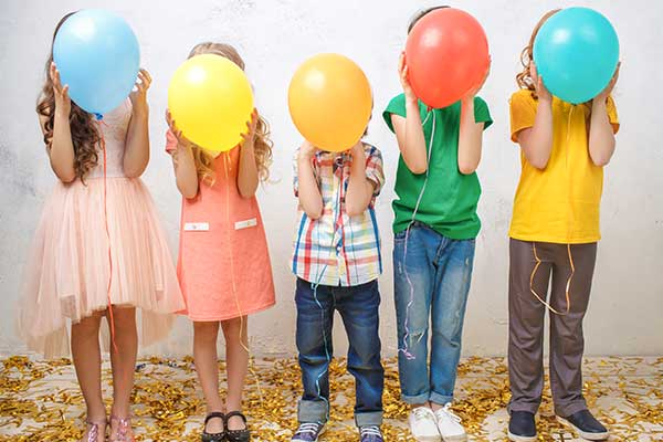 images of children holding balloons in front of their face